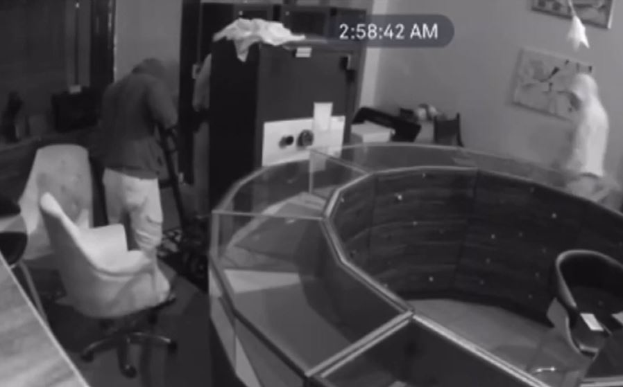 Second mage of subjects wheeling safe out of store